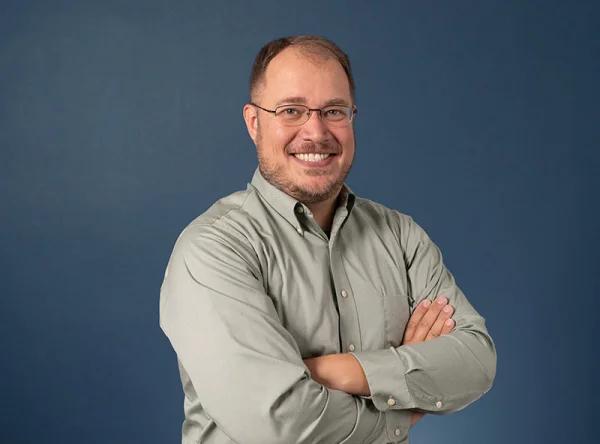 a man with glasses and a gray shirt