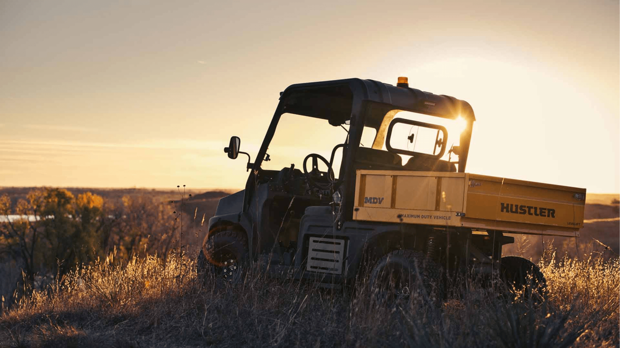 A side by side in a wheat field at dawn