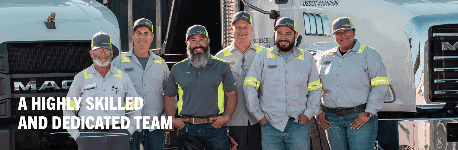 Group of GGR team members in uniform standing in front of company trucks, smiling proudly beneath the text 'A highly skilled and dedicated team.