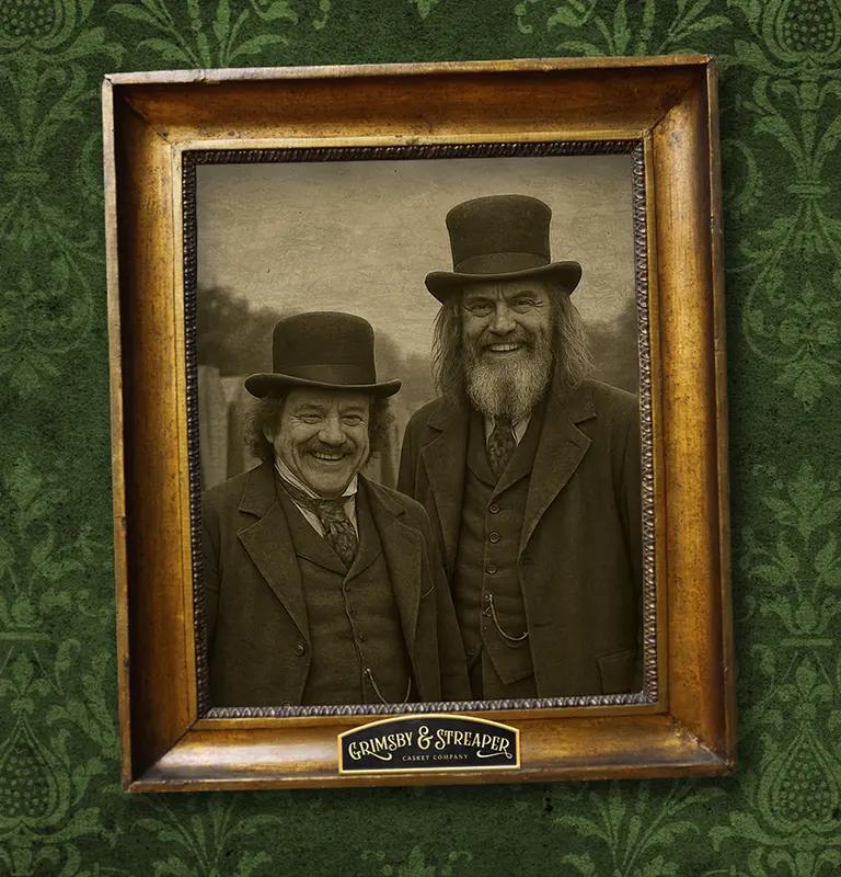 Old-fashioned sepia photograph of two Victorian-era men posing together, framed in distressed gold wood on ornate dark green wallpaper.