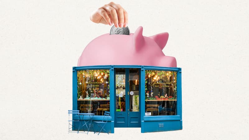 a pink piggy bank sitting in front of a store
