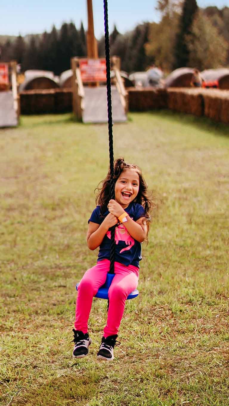 Smiling girl on a rope swing